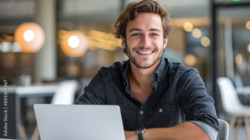 Sticker Portrait of a attractive professional man in his late twenties, smiling and sitting at an office desk with open laptop on it, wearing dark shirt, white chairs around the table. Generative AI.