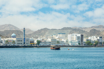 Obraz premium Mutrah promenade panorama with bay and traditional dhow boat anchored, Muscat, sultanate Oman