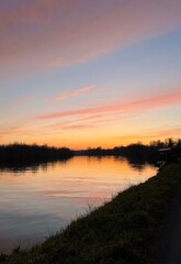 Beautiful sunset over the river or  lake reflection of pink clouds, calm nature wallpaper