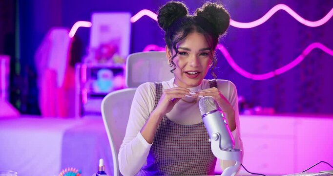 Woman, content creator and microphone for live streaming in neon with talking, happy and nail tapping. Girl, influencer and vlogging for social media followers with sensory audio, sounds and relax