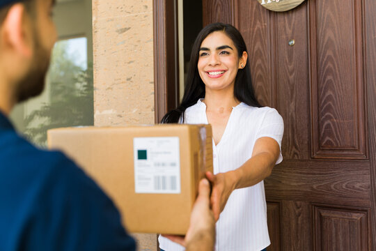 Woman joyfully accepting a delivery from a courier at her doorstep