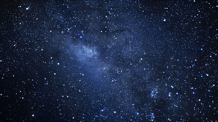 A panoramic view of the Milky Way galaxy at night, with dense scattering of stars across the dark blue sky.