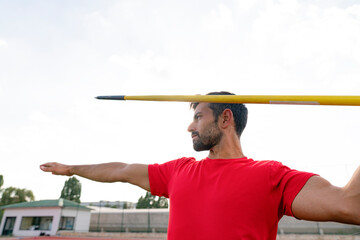 Male athlete throwing javelin at stadium