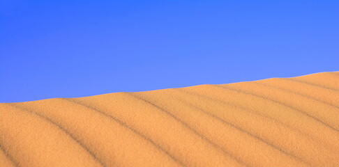 Sunset over the desert of Al Khatim in Abu Dhabi, Emirates. Golden Sand Dune Desert Landscape Panorama. Beautiful sunset over the sand dunes