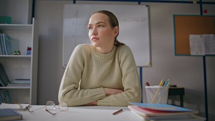 Tired teacher stretching shoulders at class room closeup. Woman taking break
