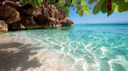 A secluded tropical beach with stunning crystal-clear waters framed by rocky outcrops and lush foliage, perfect for a tranquil and serene getaway under a blue sky.