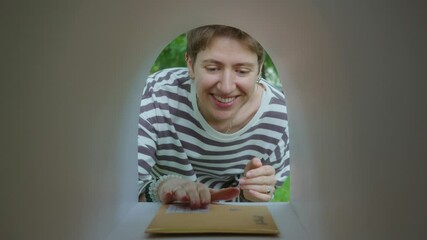 Young happy woman opening mailbox, picking up letter and clapping hands. View from inside of mailbox