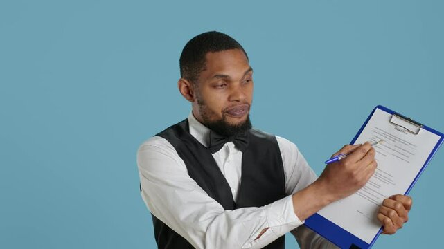 Hotel concierge showing the check in forms for registration at the five star resort, needs a signature for legal process and formalities. Bellhop receptionist welcoming guests. Camera A.