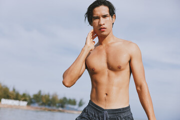 Smiling Asian Man Enjoying Tropical Swim in Blue Ocean Water on Summer Vacation