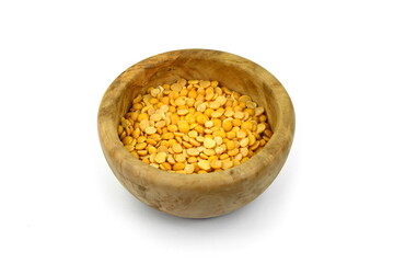 Toor dal or split yellow lentils in a wooden bowl isolated. Split Chickpea in a Bag Also Know as Chana Dal, Yellow Chana Split Peas, Dried Chickpea Lentils or Toor Dal isolated on white Background