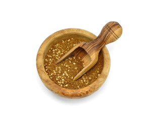 Zaatar spice in a wooden bowl isolated on white. Pile of zatar (za'atar), a middle eastern spice...