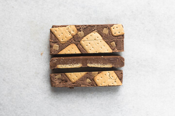 Overhead view of chocolate fudge with cookies and fudge pieces on a white tray, Top view of hazelnut chocolate fudge cut into pieces, fudge cookie candy on a white granite countertop