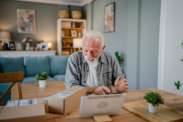 senior man sit at home hold post package delivery present or order