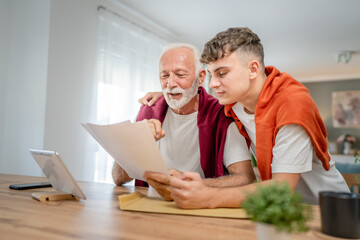 Obraz premium Senior man grandfather and caucasian man teenager boy grandson receive letter read good news student get scholarship or invitational letter from university share excitement real people