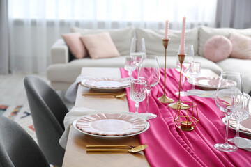 Beautiful table setting with candles and pink accent in dining room