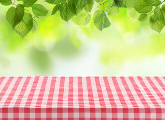 Picnic tablecloth on table under tree branches outdoors