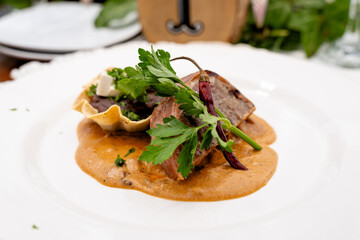 slice of gourmet steak with grilled vegetables and sauce