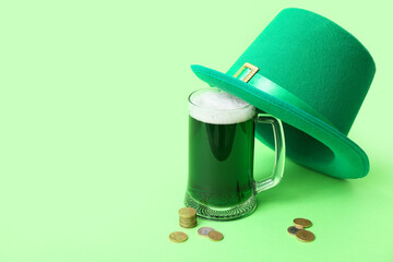 Glass of beer with leprechaun hat and coins on green background. St. Patrick's Day celebration