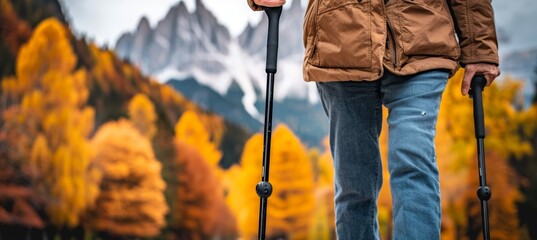 Hiker s hand with trekking pole against towering majestic mountain range scenery