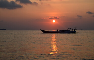 The sun is clearly visible before it sets, from a distance fishing boats add to the beauty of the atmosphere at Gelam Beach, Karimunjawa Islands, Central Java, Indonesia