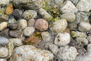 water flowing over rocks at the edge of the lake