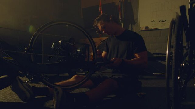 Para athlete in a garage adjusting his bike