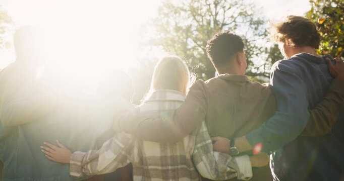 Park, walking and back of people with hug for outdoor adventure, support and care on holiday. Nature, sunshine and friends with travel by trees at countryside for vacation, trust or bonding in summer