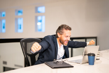Business worker with laptop at office. Employee remote working in modern office. Business man on online meeting. Excited business man working online. Mature business man using laptop at workplace.