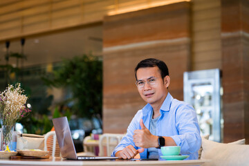 Close-up of businessman talking on phone in office and drinking coffee.