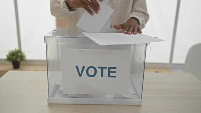 An african american man casting a vote in an electoral ballot box in an indoor voting room, emphasizing the democratic voting process and the importance of civic engagement.