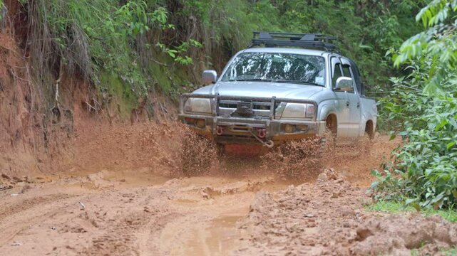 Cars running on off-road roads and splashing mud on natural paths. Off-road travel on muddy road. Suv offroad 4wd car rides through muddy puddle, off-road track road, with a big splash.