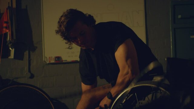 Para athlete adjusting his bike in his garage