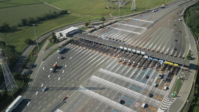 Aerial view of an Italian highway toll booth. Cars queuing up to pay the highway toll and automatic paying lanes.