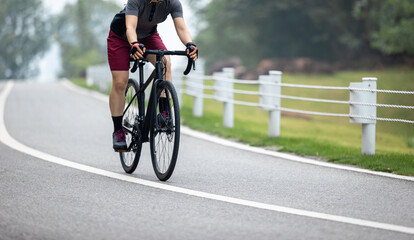 Woman cycling on summer park trail