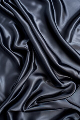 Obraz premium A close-up shot of smooth, black silk fabric with elegant folds, showcasing its luxurious texture and sheen, perfect for background or design projects.