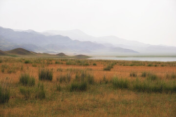 Obraz premium Salty Lake Tuzkol in Kazakhstan and its steppe shores and mountains in the gradient haze of an autumn morning