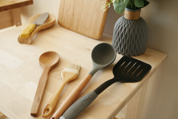 A neat display of wooden and silicone kitchen utensils on a wooden table in an organized manner