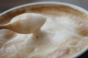 A detailed view of a frothy cappuccino with foam, ideal for indulgence and relaxation
