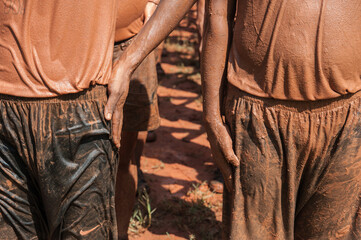 Police practice field training on muddy ground.