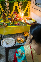 devotee worship to holy hindu god ganesha idol with holy offering at home at ganesh chaturthi