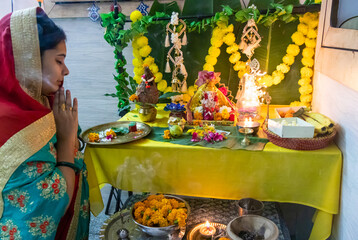 devotee worship to holy hindu god ganesha idol with holy offering at home at ganesh chaturthi