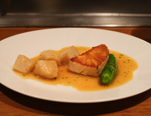 ソテーされた帆立貝とサーモンとししとうがらし