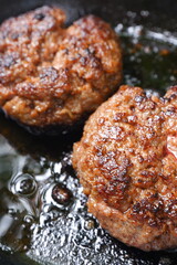 ハンバーグステーキをフライパンで、ジュージュー音をさせながら焼く
