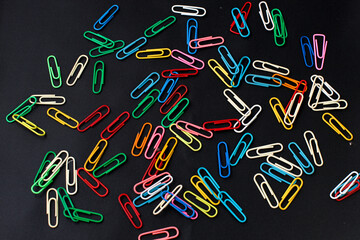 Colored paper clips isolated on black background