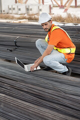 Portrait caucasian engineer man use notebook computer working at precast cement outdoor factory	