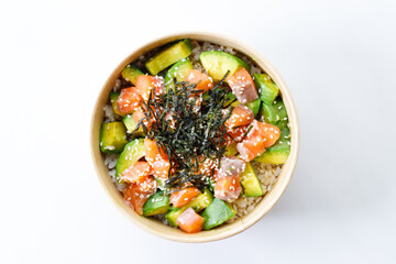 poke bowl with diced raw salmon fish and avocado on sushi rice in paper container.