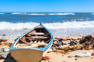 Small Sea Adventure Decoration / Vintage model miniature boat at wild baltic sea coast (copy space)