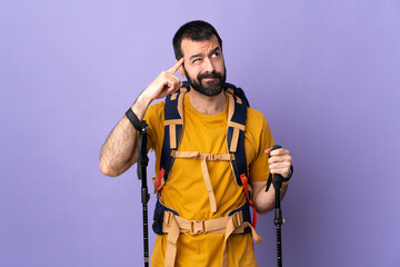 Caucasian handsome man with backpack and trekking poles over isolated background having doubts and thinking
