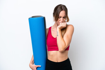 Young sport woman going to yoga classes while holding a mat isolated on white background having doubts