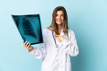 Young doctor woman holding radiography over isolated background with surprise facial expression